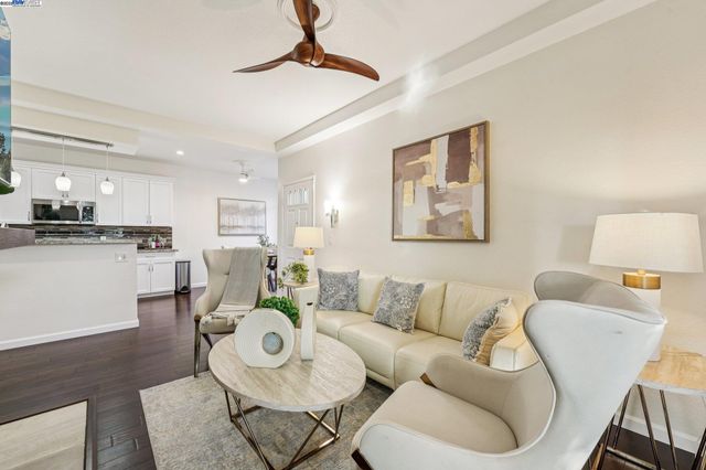 a living room with furniture and a view of kitchen