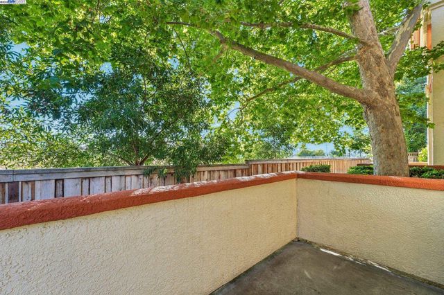 a view of balcony with two trees in front of it