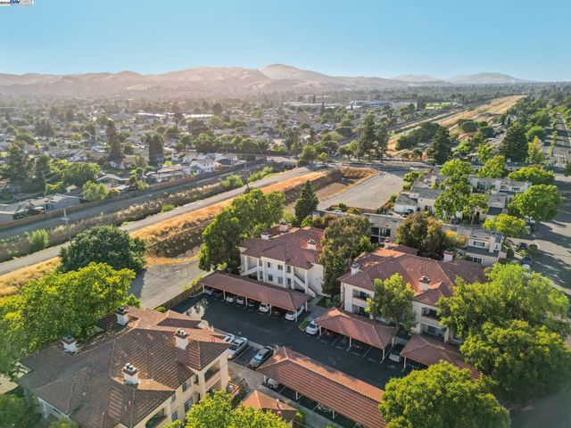 an aerial view of residential houses with outdoor space and trees