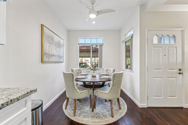 a dining room with furniture a chandelier and wooden floor