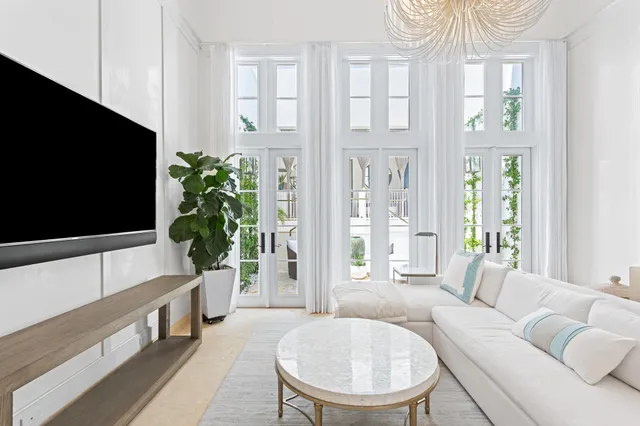 a living room with furniture a chandelier and a flat screen tv