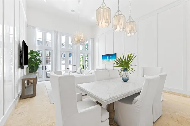 a dining room with furniture a chandelier and wooden floor