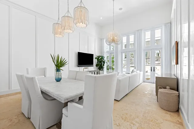 a living room with furniture a flat screen tv and a chandelier