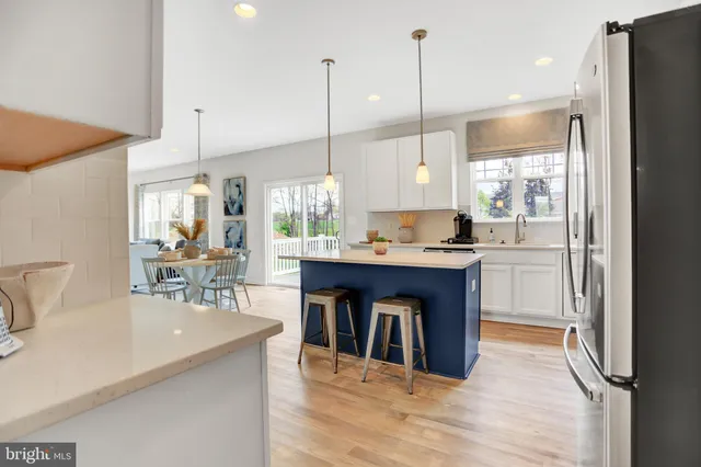 a kitchen with stainless steel appliances granite countertop a refrigerator a sink a stove and a wooden floors