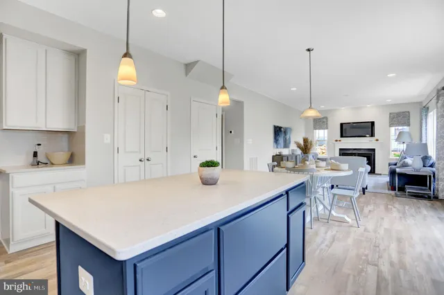 a kitchen with kitchen island a stove a sink a center island a refrigerator and a wooden floor