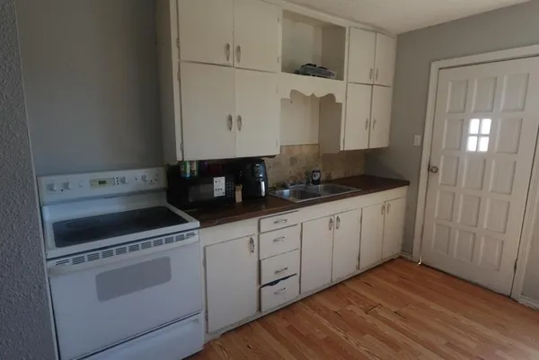 a kitchen with granite countertop white cabinets and white appliances