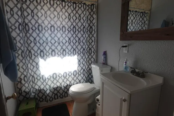 a bathroom with a sink toilet and a mirror