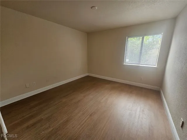 a view of a room that has wooden floor and large window