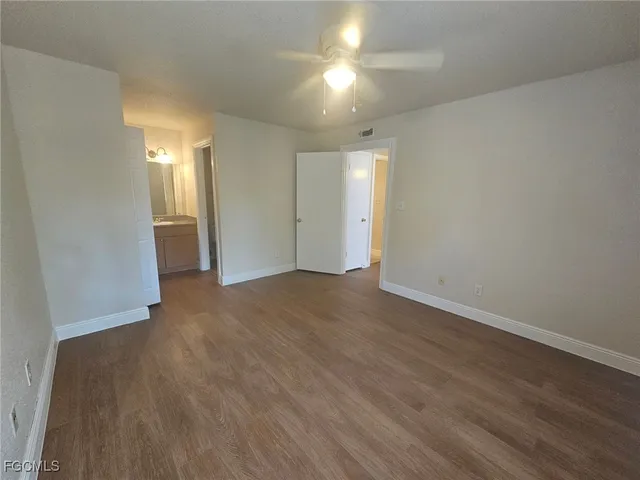 a view of empty room with wooden floor