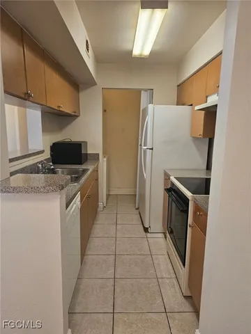 a kitchen with a refrigerator sink stove and cabinets
