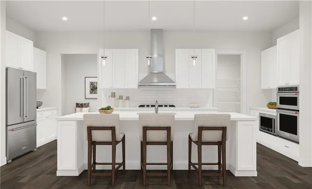 a kitchen with stainless steel appliances a white table chairs and a refrigerator