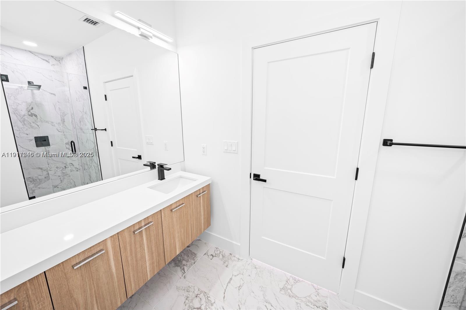 1780 Southwest 5th Street, Unit 1 Miami, FL 33135 - Photo 20 of 29 a bathroom with a double vanity sink a mirror and a bathtub