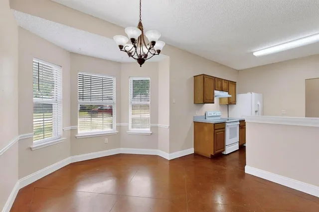 a view of an empty room with a kitchen