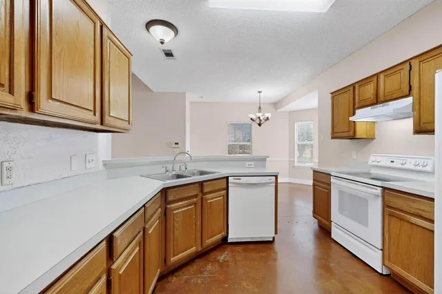 a kitchen with stainless steel appliances granite countertop a sink stove and cabinets