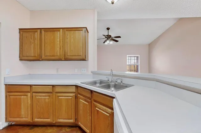 a kitchen with a sink cabinets and a window