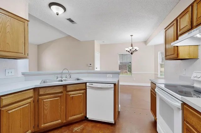 a kitchen with sink stove and cabinets