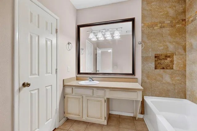 a bathroom with a sink vanity mirror and bathtub