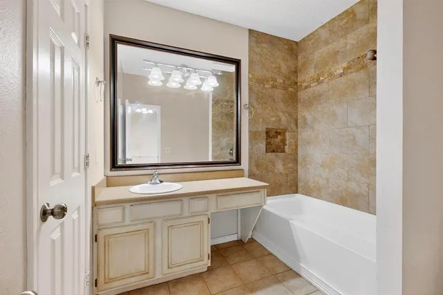 a bathroom with a tub a sink and a large mirror