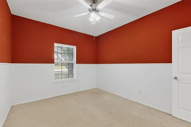 an empty room with a window and a ceiling fan