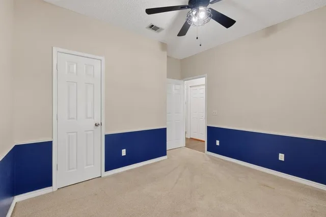 a bedroom with a dresser and a ceiling fan