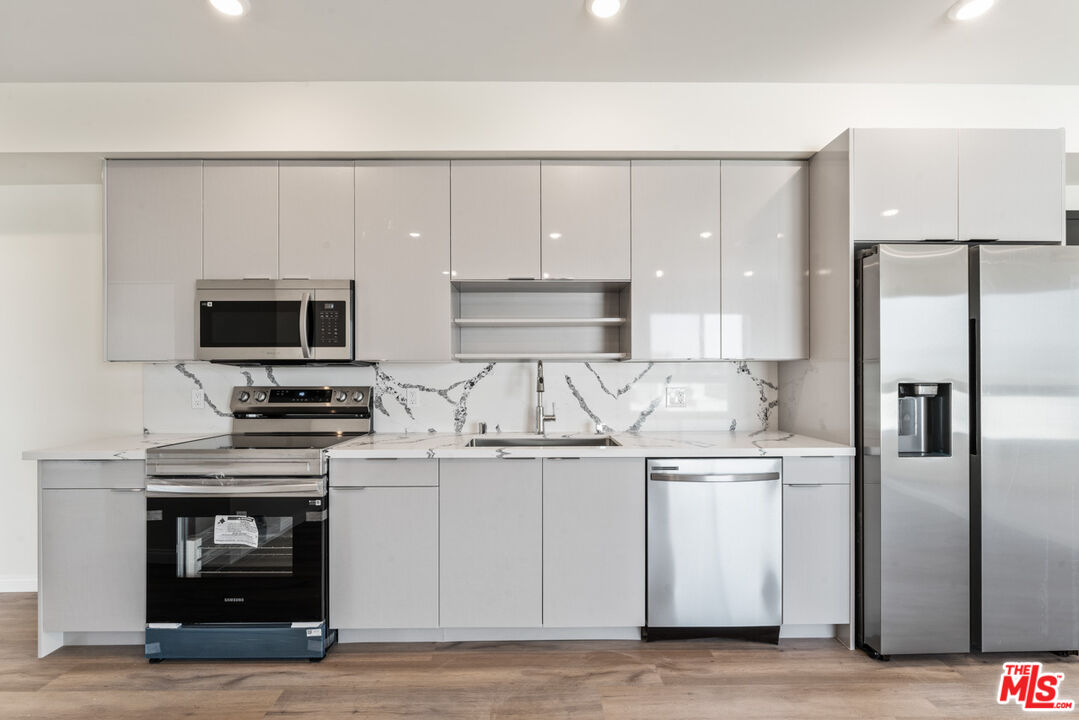 3105 Bellevue Avenue, Unit 204 Los Angeles, CA 90026 - Photo 5 of 20 a kitchen with stainless steel appliances a stove microwave and refrigerator