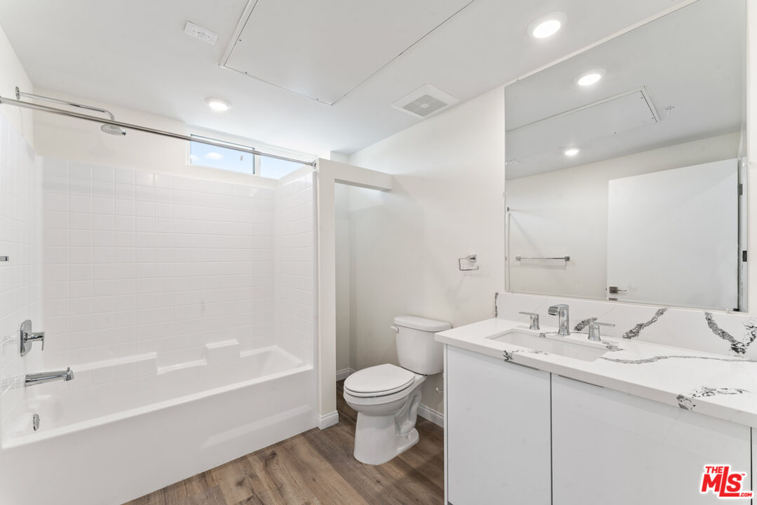 3105 Bellevue Avenue, Unit 204 Los Angeles, CA 90026 - Photo 7 of 20 a bathroom with a granite countertop sink toilet a shower and a bathtub