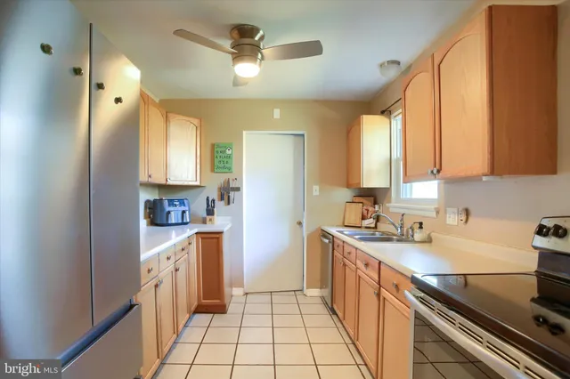 a kitchen with a sink cabinets stainless steel appliances and a window