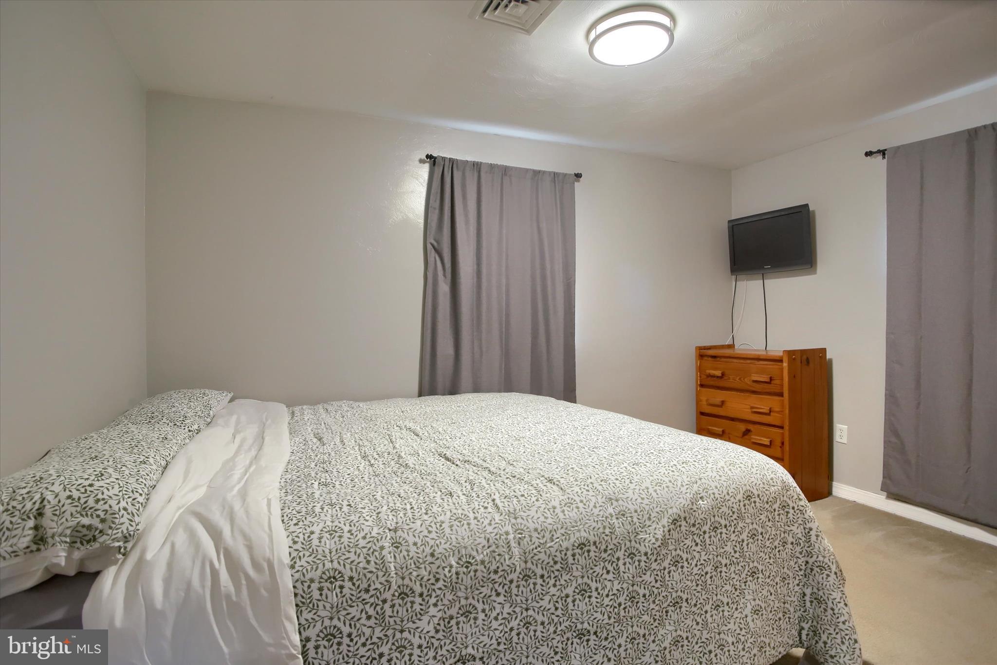 4709 Delbrook Road Mechanicsburg, PA 17050 - Photo 14 of 34 a bedroom with a bed and a television