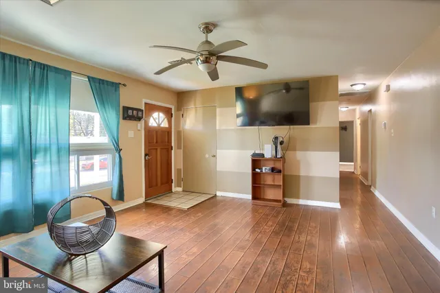 a living room with furniture and a wooden floor