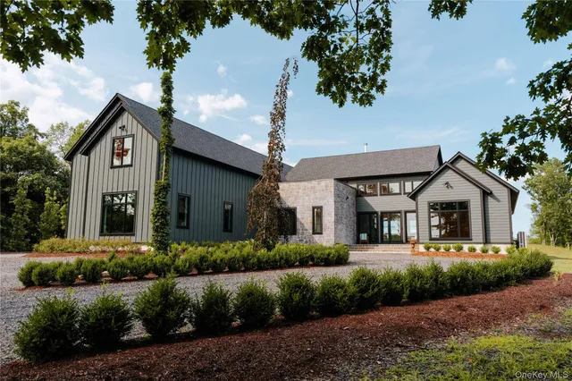 a front view of a house with a yard and green space