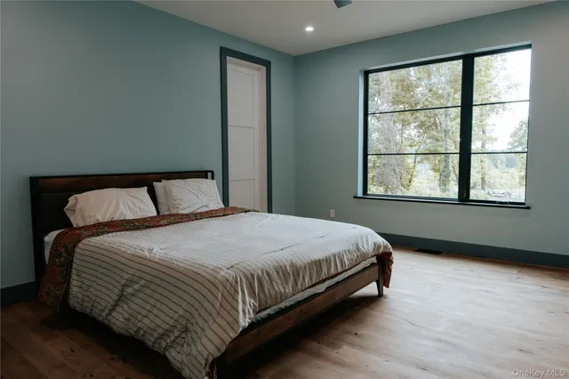 a bedroom with a bed and wooden floor