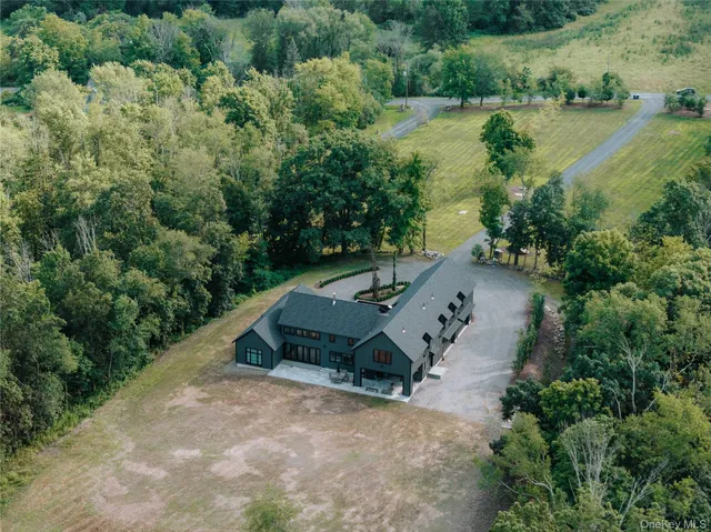 an aerial view of a house with a yard and lake view