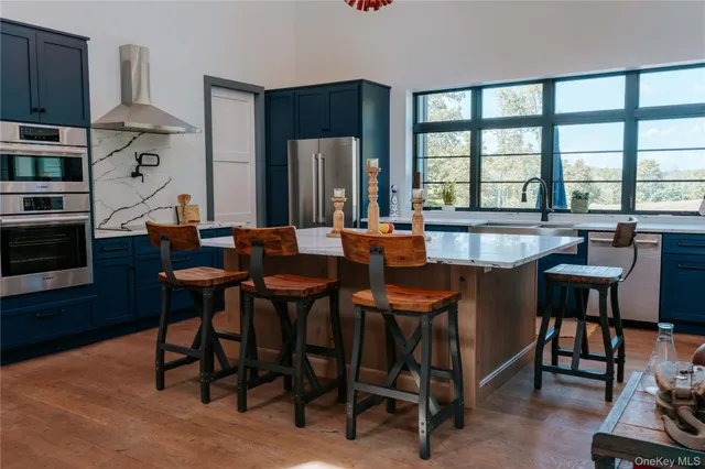 a dining hall with stainless steel appliances a table and chairs with wooden floor