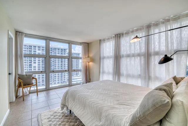 a bedroom with a bed and a large window