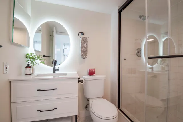 a bathroom with a sink a toilet and shower