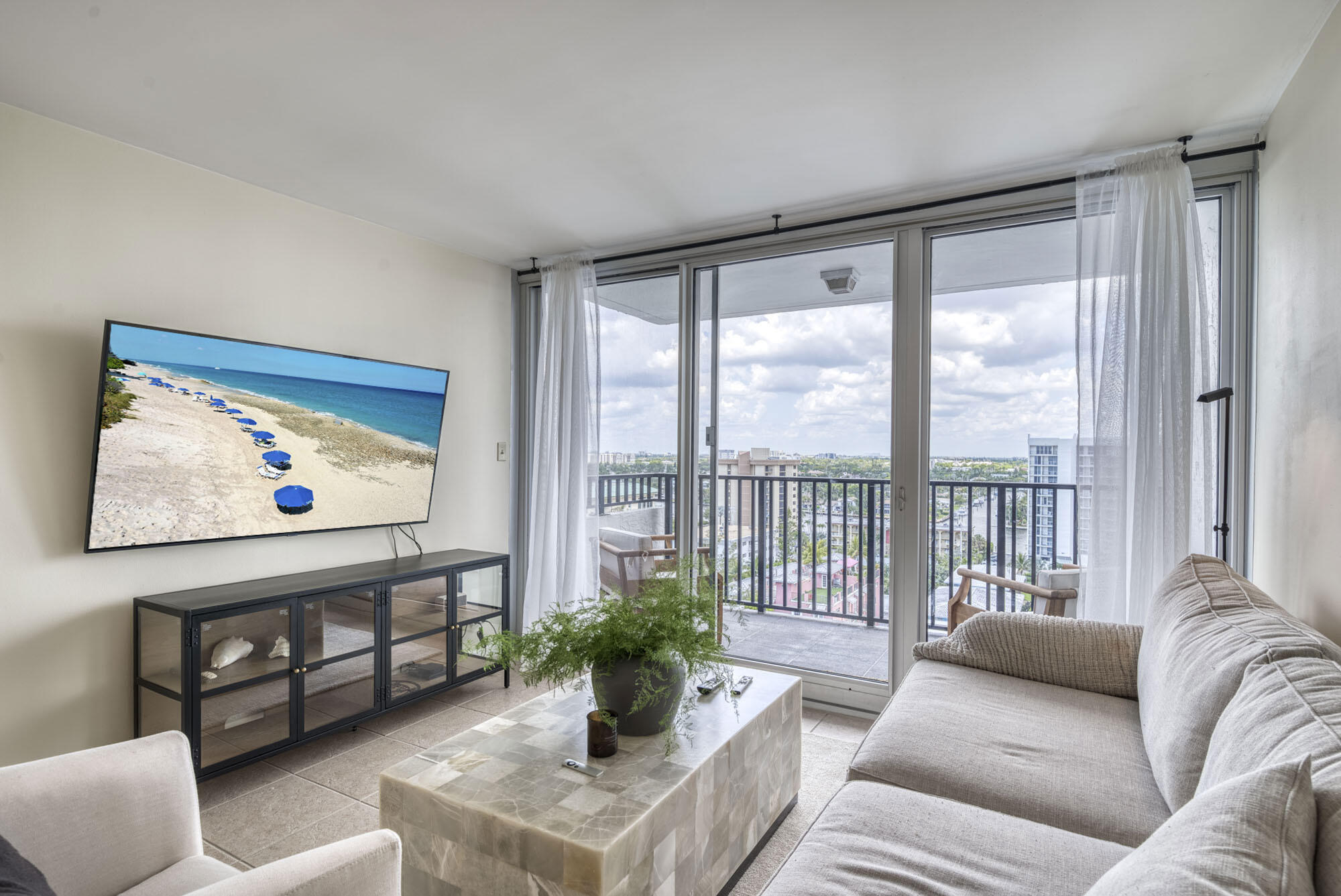 525 North Ocean Boulevard, Unit 1215 Pompano Beach, FL 33062 - Photo 4 of 16 a living room with furniture and a large window with potted plants