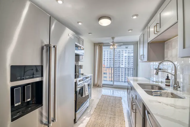 a kitchen with granite countertop a sink stove and refrigerator