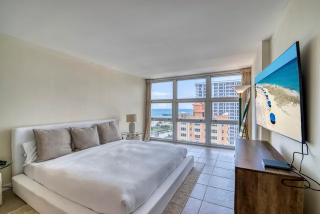 a bedroom with a large bed and a flat tv screen