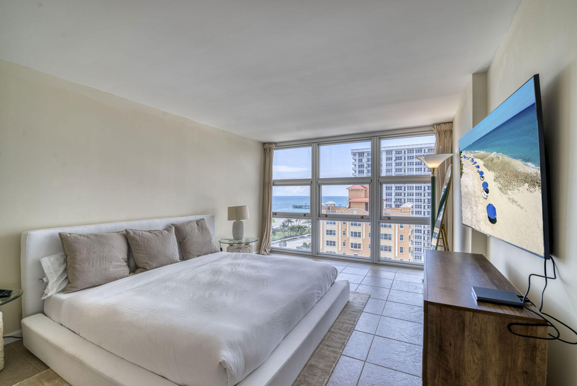 525 North Ocean Boulevard, Unit 1215 Pompano Beach, FL 33062 - Photo 10 of 16 a bedroom with a large bed and a flat tv screen