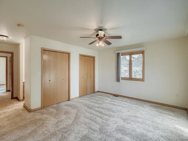 an empty room with fan and windows