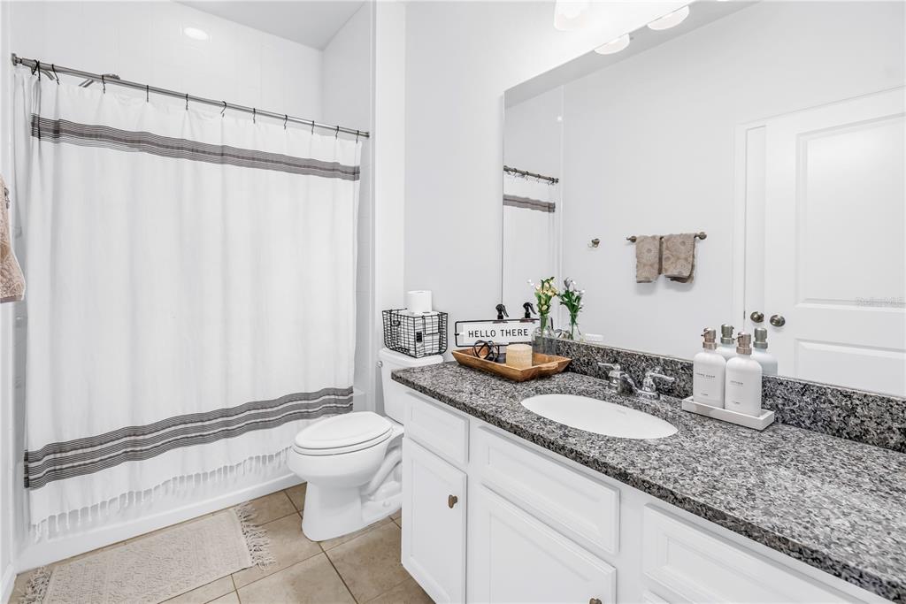 13229 Orca Sound Drive Riverview, FL 33579 - Photo 18 of 37 a bathroom with a granite countertop sink a toilet and a mirror