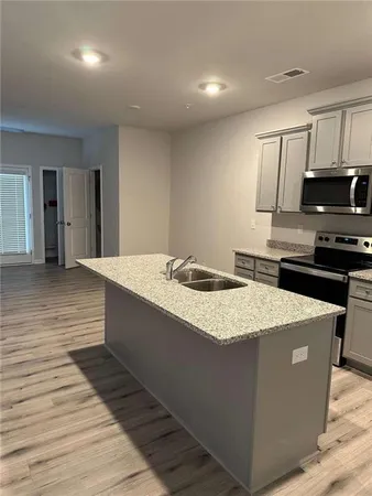 a kitchen with stainless steel appliances kitchen island granite countertop a stove a sink and a refrigerator