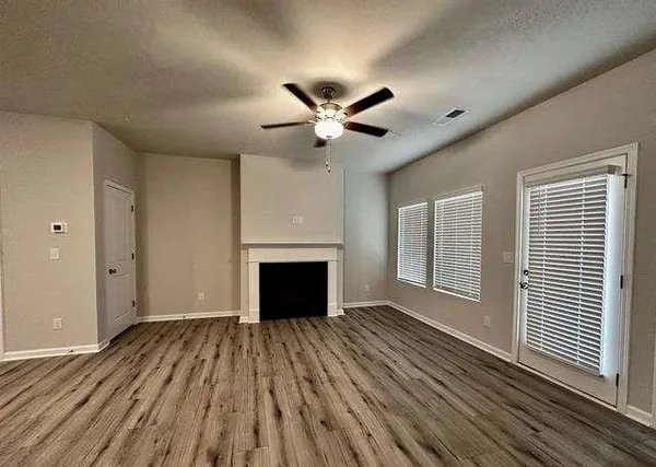 a view of an empty room with a fireplace and a window