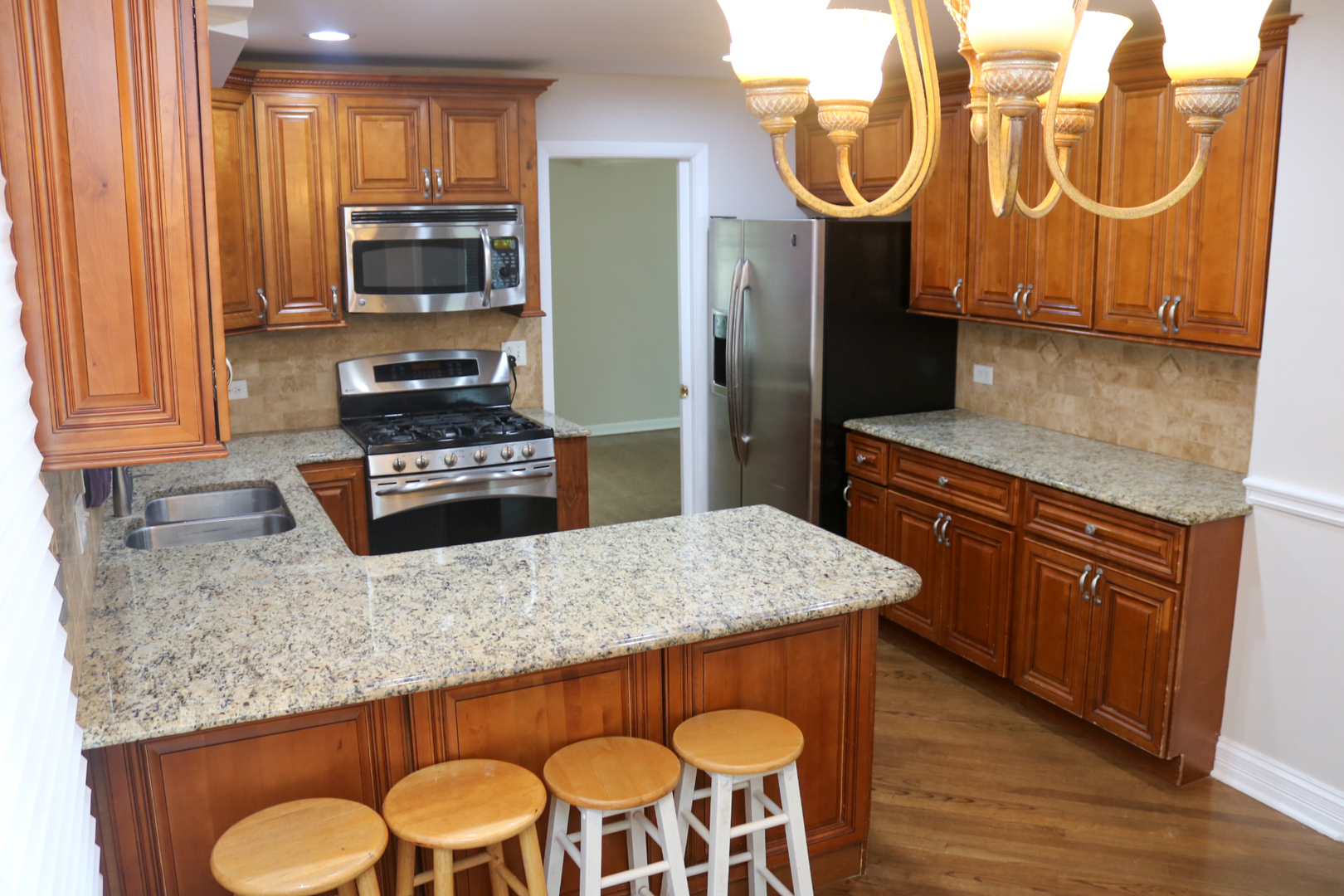 401 Dewey Avenue Evanston, IL 60202 - Photo 5 of 20 a kitchen with stainless steel appliances granite countertop a stove top oven a sink dishwasher and wooden cabinets with wooden floor