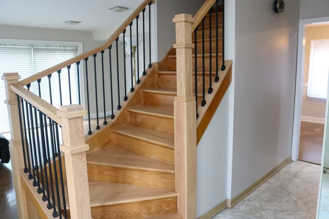 a view of staircase with wooden floor and white walls