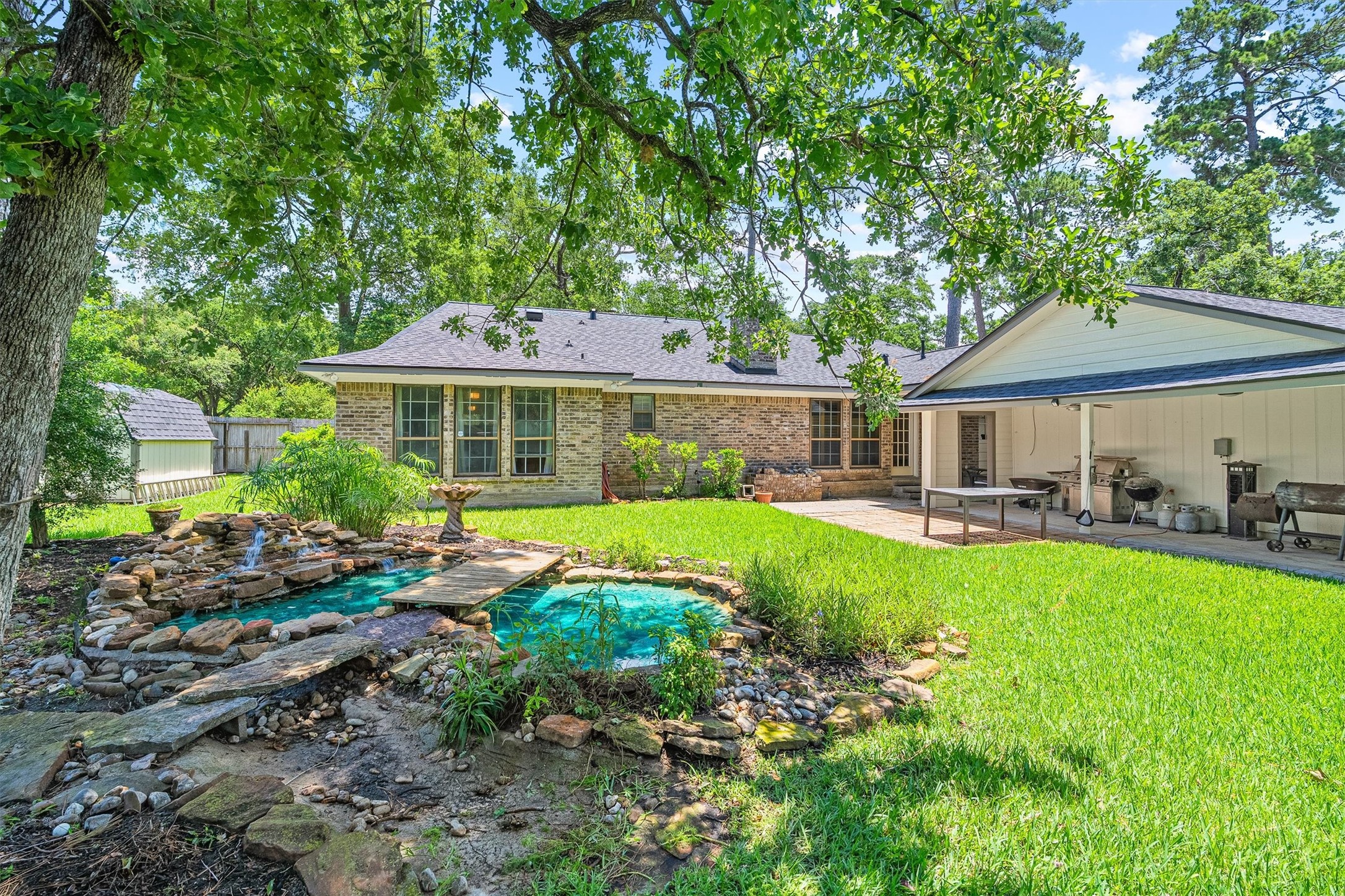 826 North Rivershire Drive Conroe, TX 77304 - Photo 34 of 46 And here it is — the koi pond. Stone surround, water feature, lush landscaping, and mature trees canopying the whole space. This backyard has a tranquility to it that you simply cannot manufacture. Come see it in person.