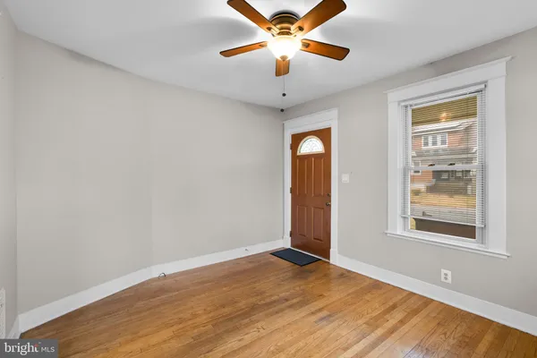 a view of an empty room with window and wooden floor