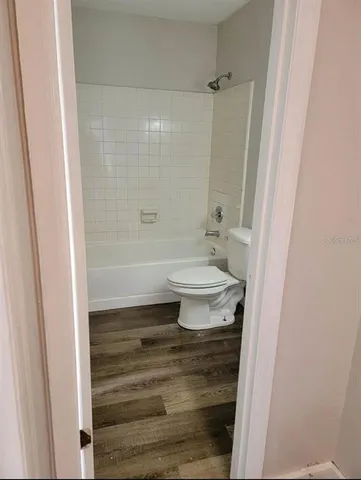 a bathroom with a toilet a sink a mirror a vanity and shower