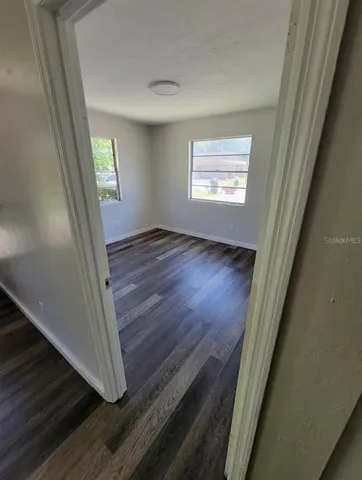 a view of a hallway with wooden floor