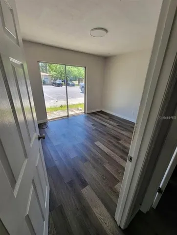 a view of a hallway with wooden floor and entryway